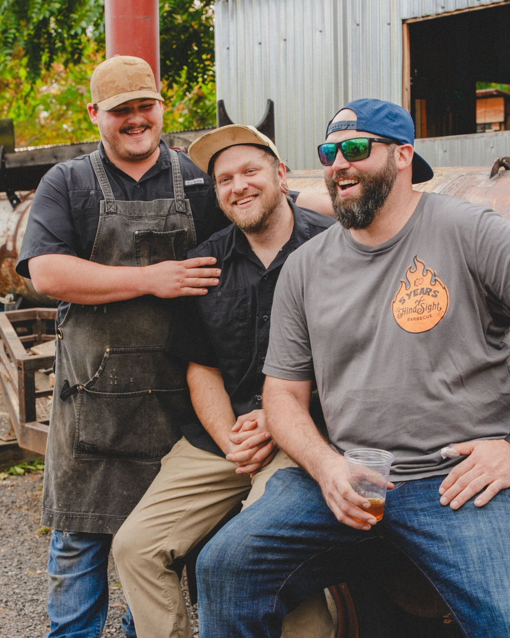 Three of the Hindsight BBQ crew laughing by the smoker